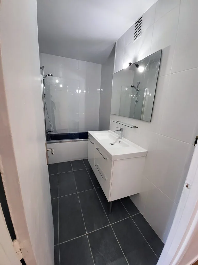 Salle de bain rénovée avec nouveau carrelage et meuble vasque