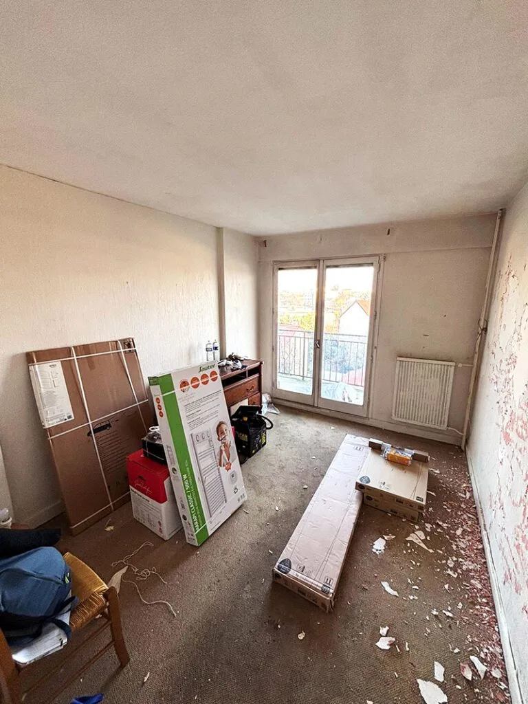Chambre avant les travaux, avec sol usé et murs défraîchis.