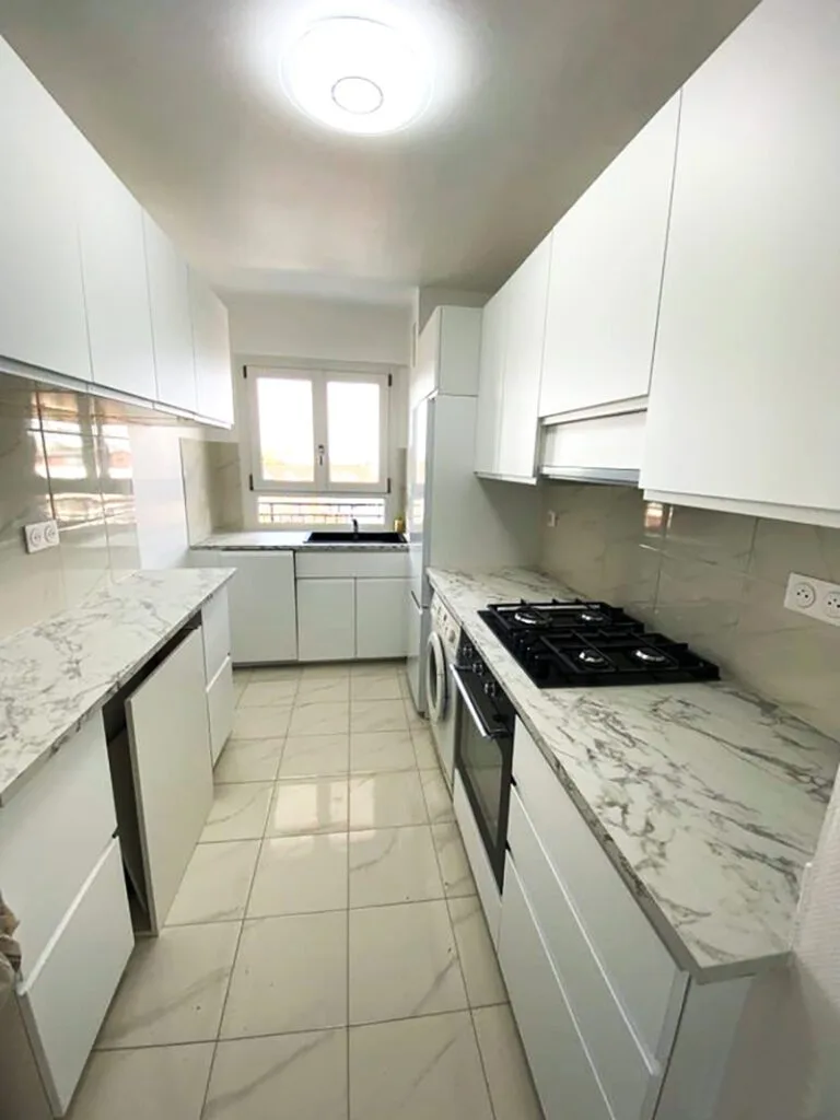 Cuisine entièrement rénovée avec meubles modernes et carrelage neuf.