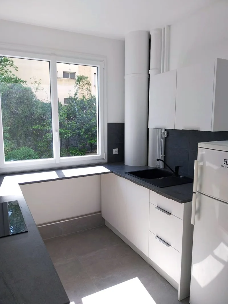 Cuisine moderne avec évier, réfrigérateur encastré et mobilier neuf.