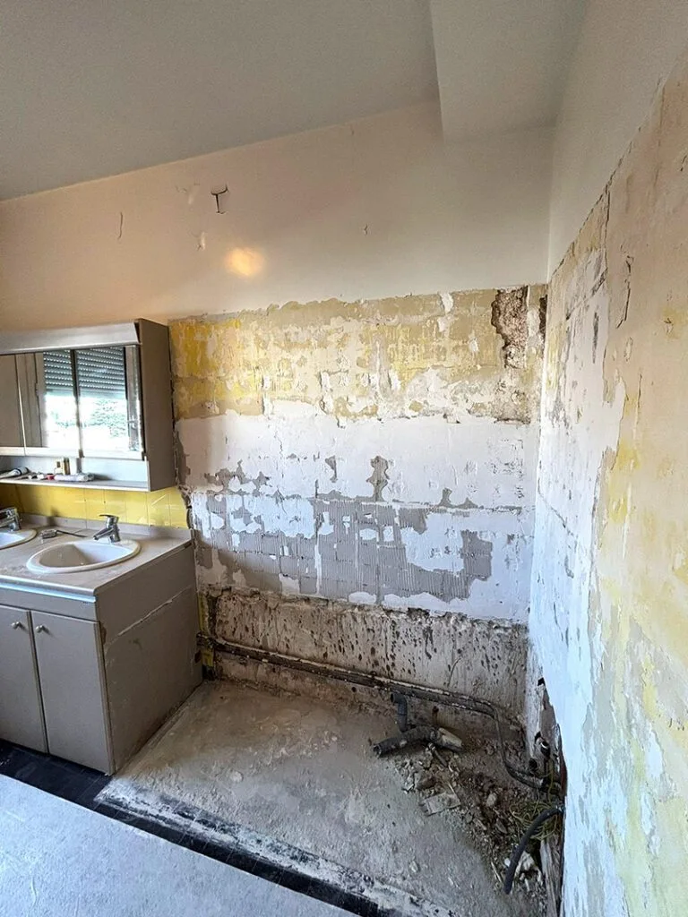 Salle de bain de 6m² pendant les travaux, avec carrelage mural et équipements démolis
