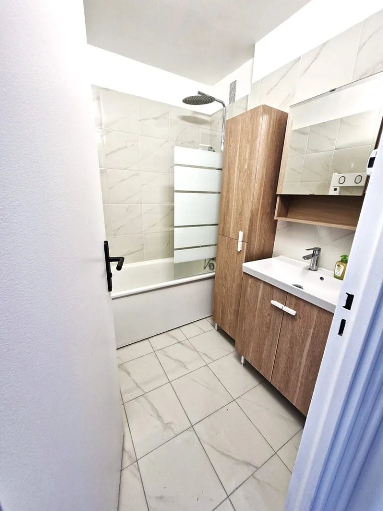 Salle de bain rafraîchie avec nouveau meuble vasque et carrelage mural.