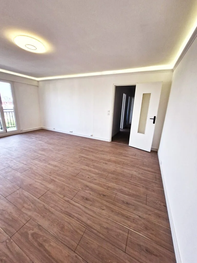 Salon rénové avec parquet neuf et murs repeints.