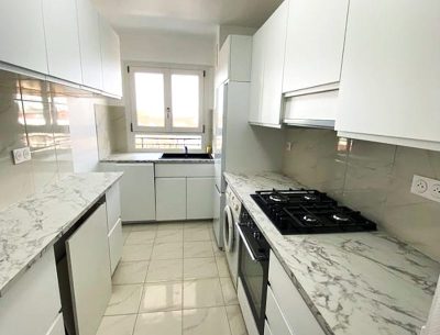 Cuisine entièrement rénovée avec meubles modernes et carrelage neuf.