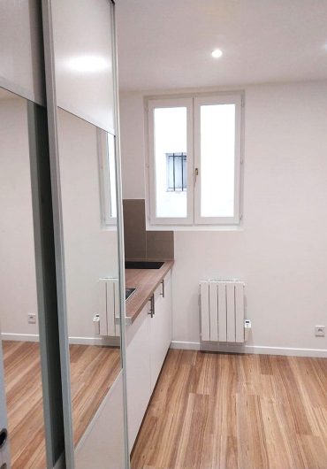 Meubles de cuisine sur mesure avec vue sur la fenêtre extérieure dans une studette rénovée à Paris.
